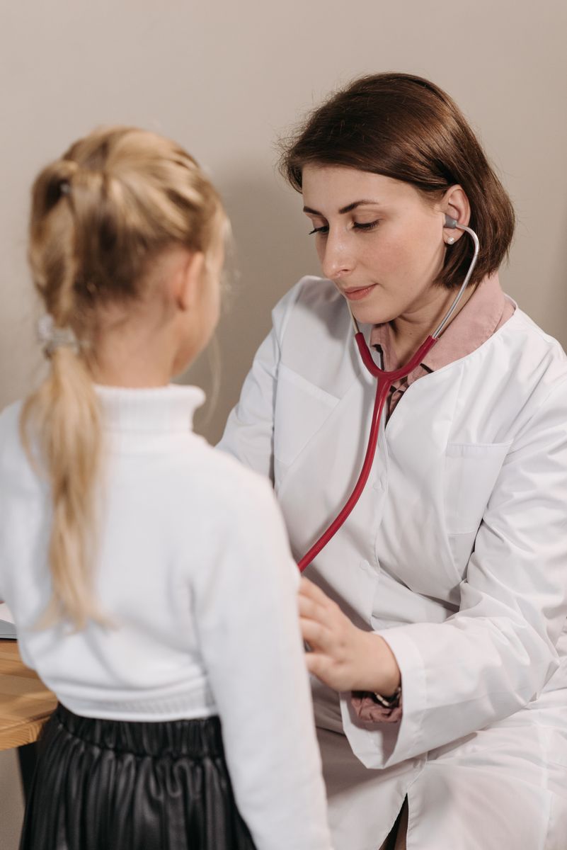 A doctor checking a young child with a stethoscope