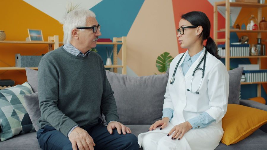 A female doctor talking with an older patient
