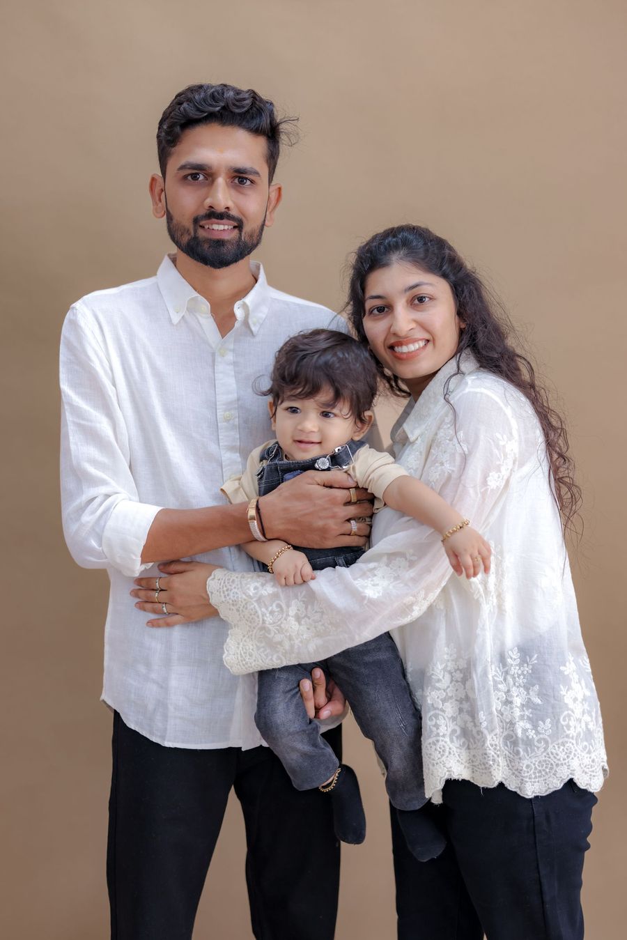 A mother and father holding their baby