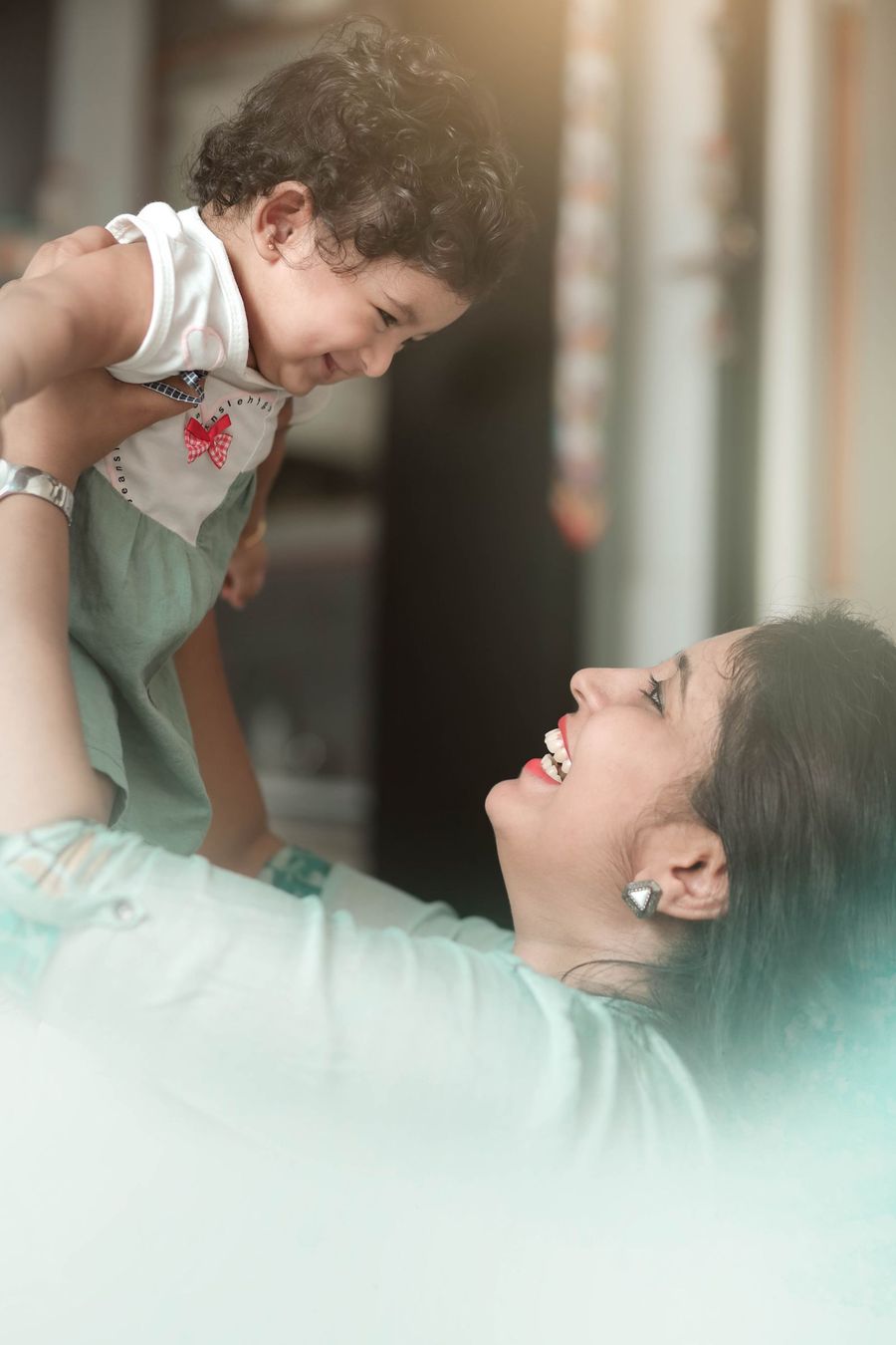 A mother holding her laughing toddler