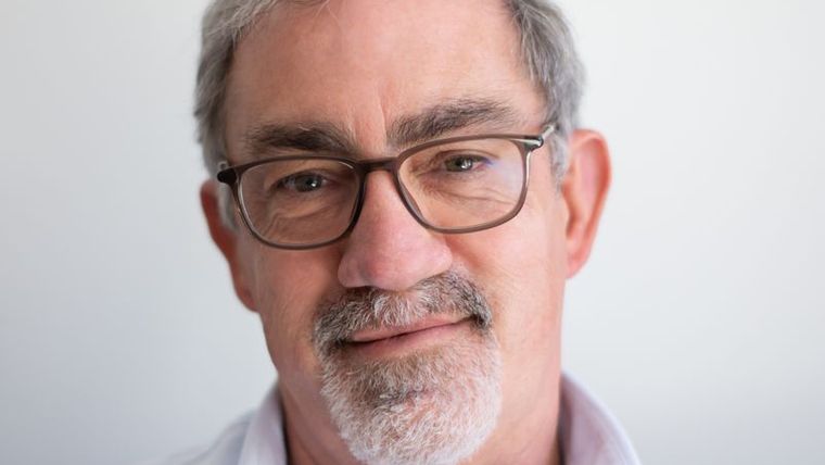 A smiling middle-aged man in glasses
